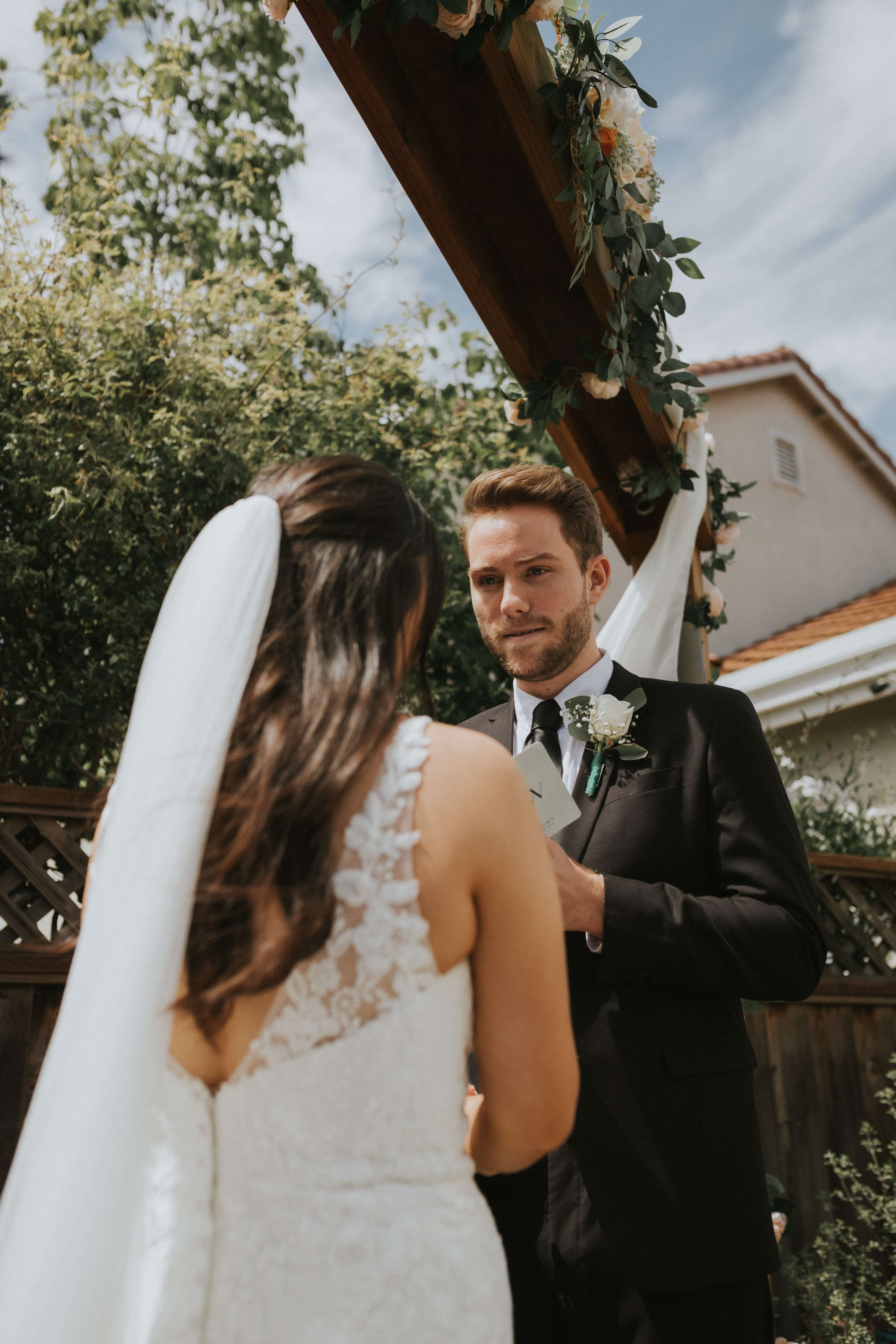 Bride and groom facing each other during their outdoor wedding ceremony